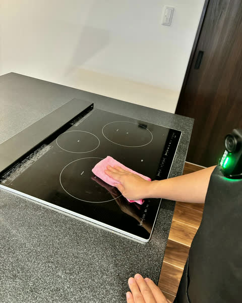 IHコンロを拭き上げるスタッフの手元