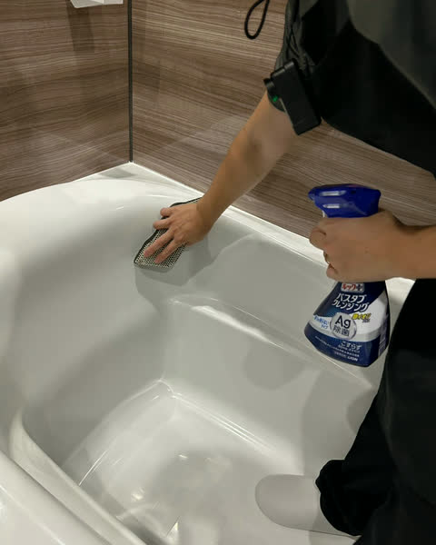 浴槽をスポンジで洗うスタッフ